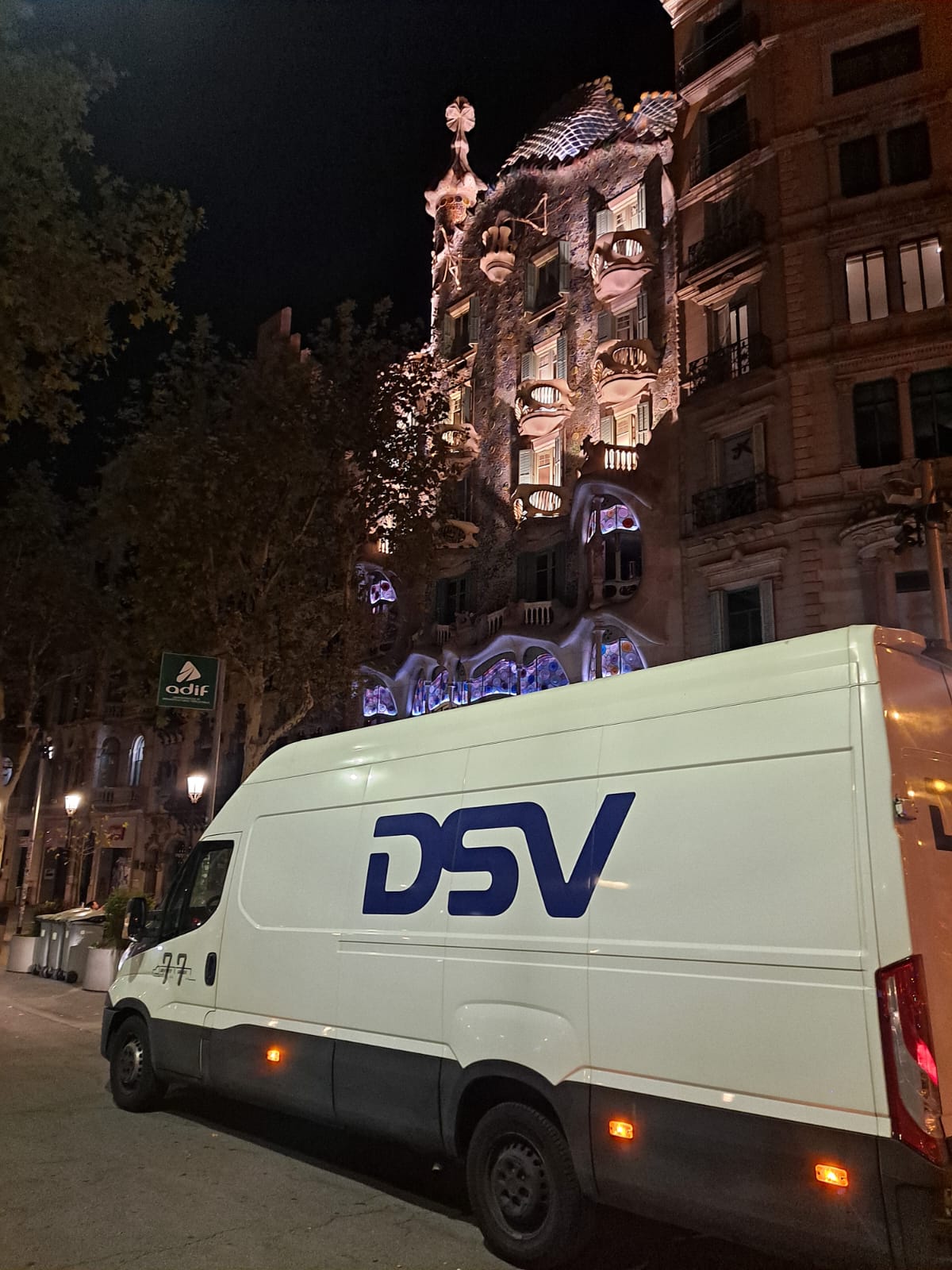 Una furgoneta de DSV estacionada por la noche frente a la Casa Batlló en Barcelona.